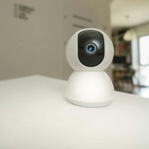 Close-up of a smart home surveillance camera on a table in an interior setting